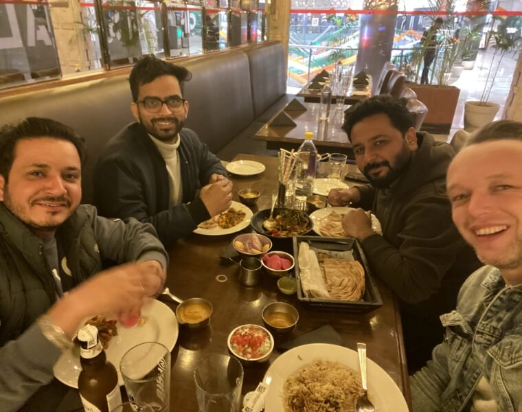 Lennart en Studio Ubique collega's uit India delen een maaltijd in New Delhi