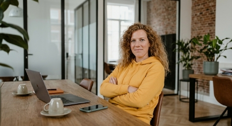 Webdesign bureau medewerker leunt achterover met armen over elkaar, uitdagende blik