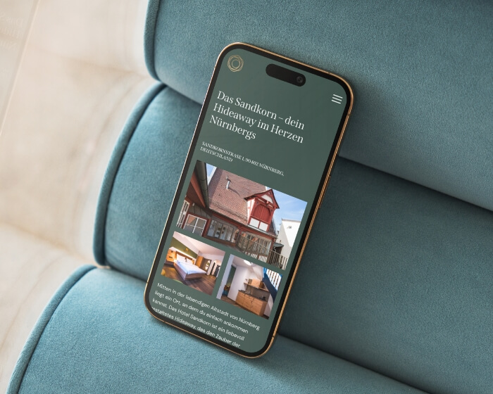 Webdesign hotel Sandkorn op smartphone, groene hero met historisch pand en kamerfoto's Neurenberg