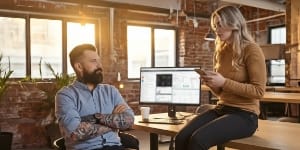 Teammates monitoring uptime as an alert arrives on phone, calm late-day office — 99.99% uptime SLA