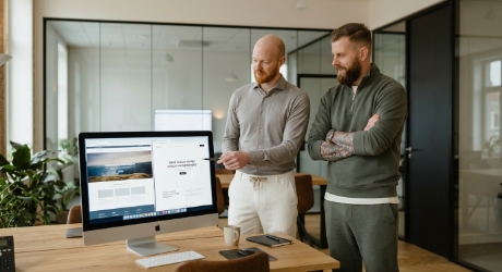 Team vergelijkt template website met custom website op iMac scherm