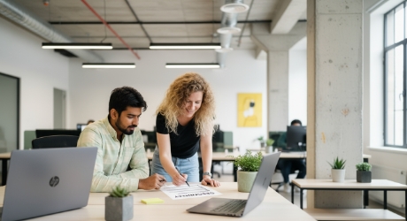 man en vrouw bespreken websitebeveiliging checklist op kantoor
