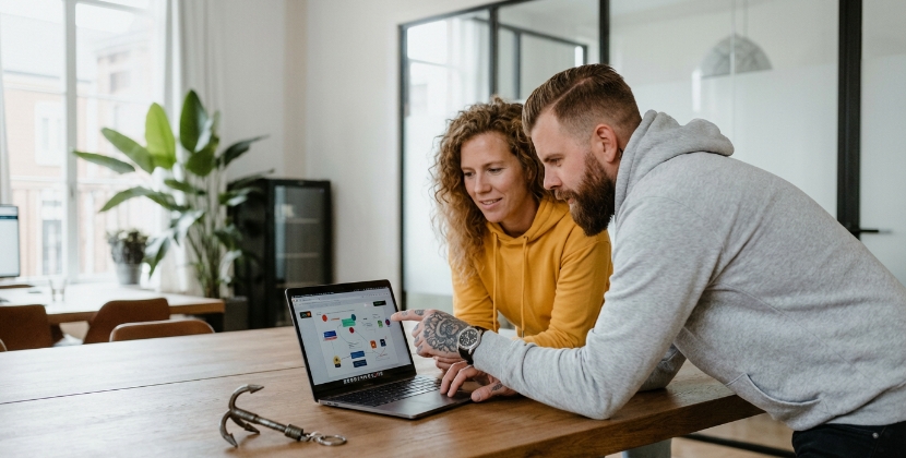 Twee collega's bespreken woordkeuze op laptop, vakjargon versus gewone taal
