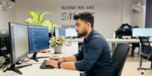 Pricing and rates, developer coding at dual monitors, estimating website development cost.