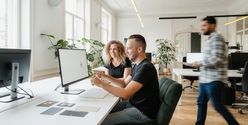 collega's evalueren SaaS onboarding scherm op grote monitor