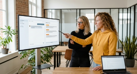 Team reviewt AI-suggestie in productinterface op groot scherm, AI UX design in de praktijk