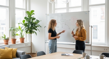 twee collega's bespreken AI SEO versus traditionele SEO strategie op whiteboard
