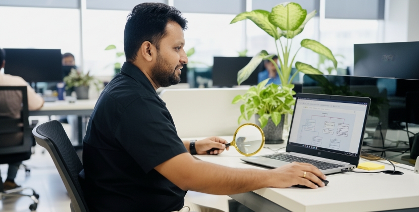 Developer analyseert website contentstructuur met vergrootglas bij laptop