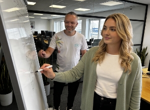 Team member sketching ideas on a whiteboard during a workshop