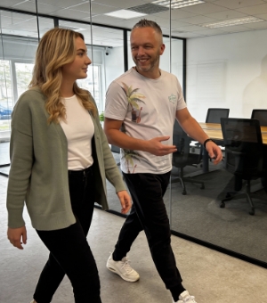 Two colleagues walking and chatting through the office