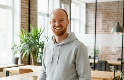 Portret van Daan, teamlid van Studio Ubique, in een moderne kantoorruimte