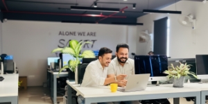 Twee developers werken samen aan laptop en planning aan bureau in kantoor