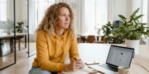 Ontwerper werkt met design en code naast elkaar op twee schermen, van ontwerp naar ontwikkeling.