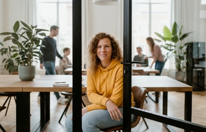 Developer zit kalm achter halfopen deur en overziet drukke werkruimte als metafoor voor backend development in Zwolle