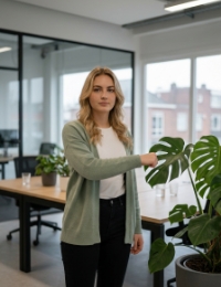 UX/UI design services specialist takes a moment beside an office plant in Zwolle