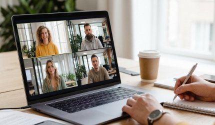 IT-uitbesteding bureau teamvideogesprek, developer neemt notities terwijl remote collega's meekijken op scherm