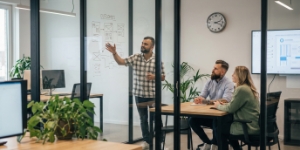 Technical SEO and AI audit session, team reviewing site issues and fixes on laptops in a glass-walled meeting room