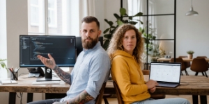 Twee developers ruggelings met eigen scherm, samenwerking tijdens het bouwen van een webshop op maat
