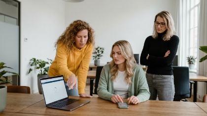 Twee collega's testen progressive web app laten ontwikkelen op laptop en smartphone in licht open kantoor