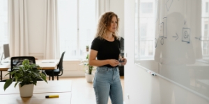 Vrouw legt DNS-instellingen uit op een whiteboard, domeinregistratie visueel toegelicht