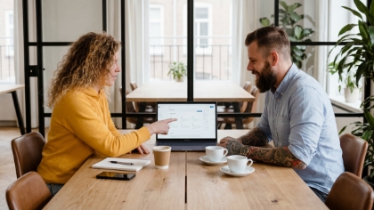 Twee collega's analyseren resultaten van een Flutter app laten ontwikkelen op groot scherm en smartphone