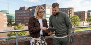 Twee collega's van een webdesign bureau overleggen samen op tablet over een klantproject