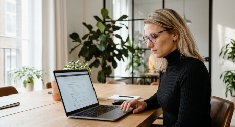 Persoon aan een bureau in een Zwols kantoor die naar een laptopscherm staart met een Google SERP met een featured snippet en AI-overzicht, geen klik, licht verwarde uitdrukking