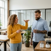 Collega's bespreken database-oplossingen bij koffiehoek in modern Zwolle kantoor