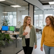 Collega's bespreken front-end frameworkkeuze tijdens loopgesprek in gang van Zwolle kantoor