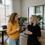 Collega's bespreken Laravel project bij koffiehoek in modern Zwolle kantoor