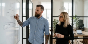 Collega's tekenen maatwerk website architectuur op whiteboard tijdens strategiesessie
