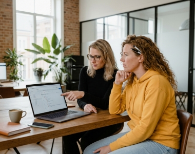 Twee developers reviewen samen Node.js REST API-respons op laptop in Zwolle kantoor