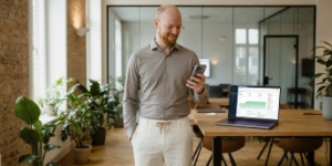 Specialist monitort website-uptime na overstap, groene statusgrafiek op laptop