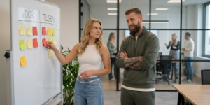 Twee collega's wegen opties af op whiteboard, rebuild versus opknapbeurt van bestaande website