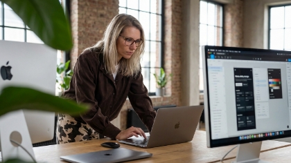 Ontwerper werkt aan een UX/UI-ontwerp in Figma op een MacBook en Apple Studio Display in het Studio Ubique kantoor in Zwolle