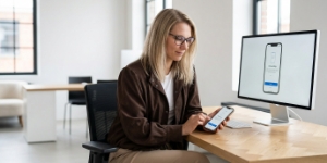 Ontwerper bekijkt app-UI met call-to-action-knoppen op een iPhone.