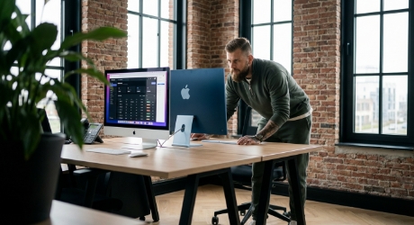 Developer reviewing a Magento to Shopify migration plan on dual monitors, with product data and redirect spreadsheets visible