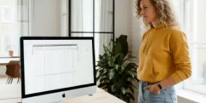 Studio Ubique team member at a desktop monitor showing a data table in the office
