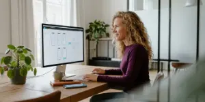 Designer mapping a mobile app navigation flow on screen and iPhone.