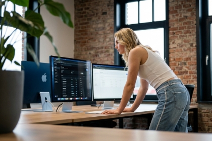 Studio Ubique team member at a dual-screen desk in the office, React.js development