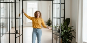 Studio Ubique team member standing in a glass door frame in a bright empty room