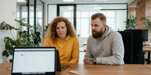 Two Studio Ubique team members reviewing an e-commerce SEO page on a laptop