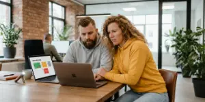 Two Studio Ubique team members studying an SEO audit on a laptop screen