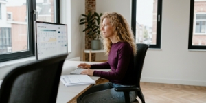 Ontwerper bestudeert een user journey map en user flows op het scherm.