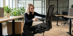 Teamlid zet een bureaustoel in elkaar in het kantoor, maatwerk