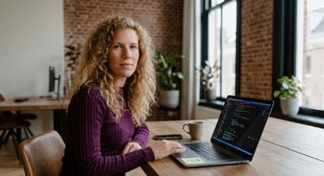 Designer at a Zwolle office desk reviewing code in a clean editor on a laptop screen