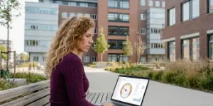 Collega bekijkt een dashboard op een laptop op een bankje buiten, tracking rond de ATS-koppeling