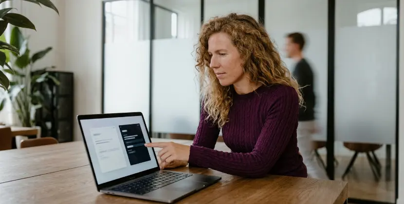 Persoon bekijkt twee panelen naast elkaar op een MacBook, wijst er een aan