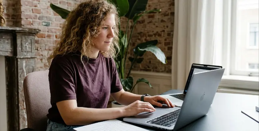 Persoon checkt rustig een dataoverzicht op laptop naast geprinte checklist
