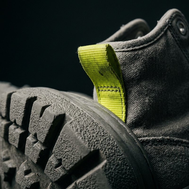 Close-up of the GRYM Concrete Runner, acid-lime heel tab and vulcanised gum sole